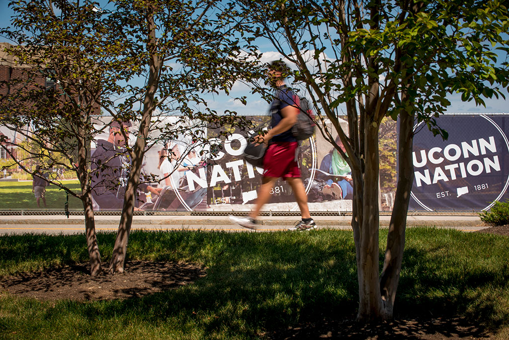 Student walks by UConn Nation banner.